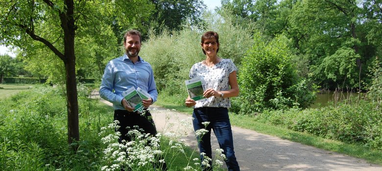 Bürgermeister Marco Diethelm und Gaby Höft präsentieren die Broschüre im Klostergarten Herzebrock die 