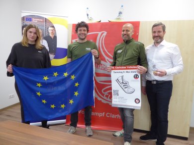 Personen halten Europaflagge und Plakat hoch