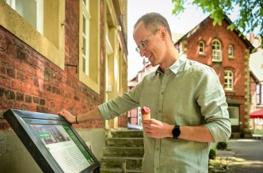 Mann mit Eis an Infotafel in Clarholz