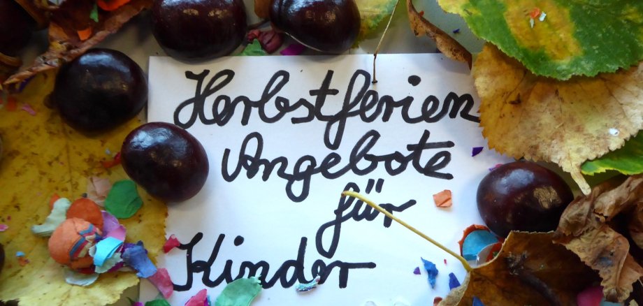 Laub und Kastanien und Schrift Herbstferien Angebote für Kinder