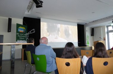 Menschen von hinten und Leinwand mit Film